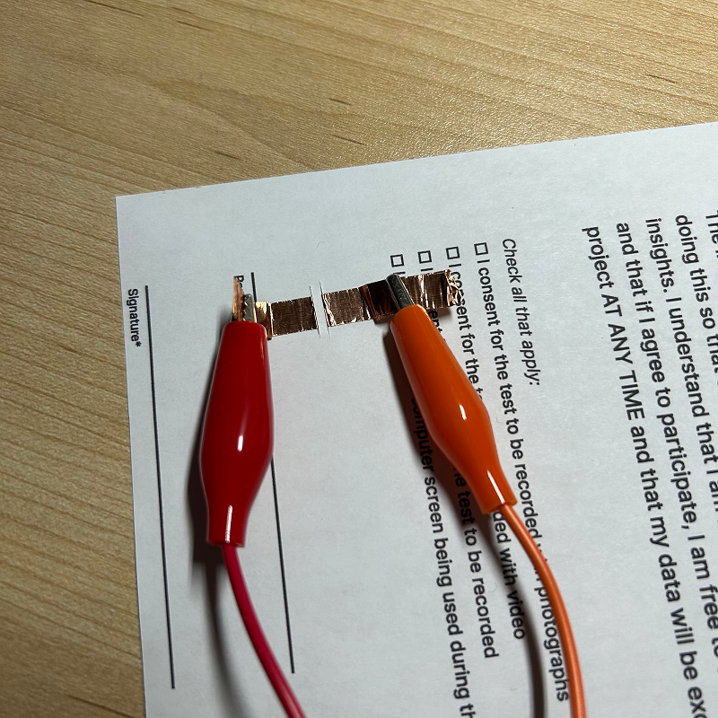 For the arcade machine idea, I would clip them directly behind the paper, but for the map design, I would extend the tape so that the clips are all clipped along the edge of the page.